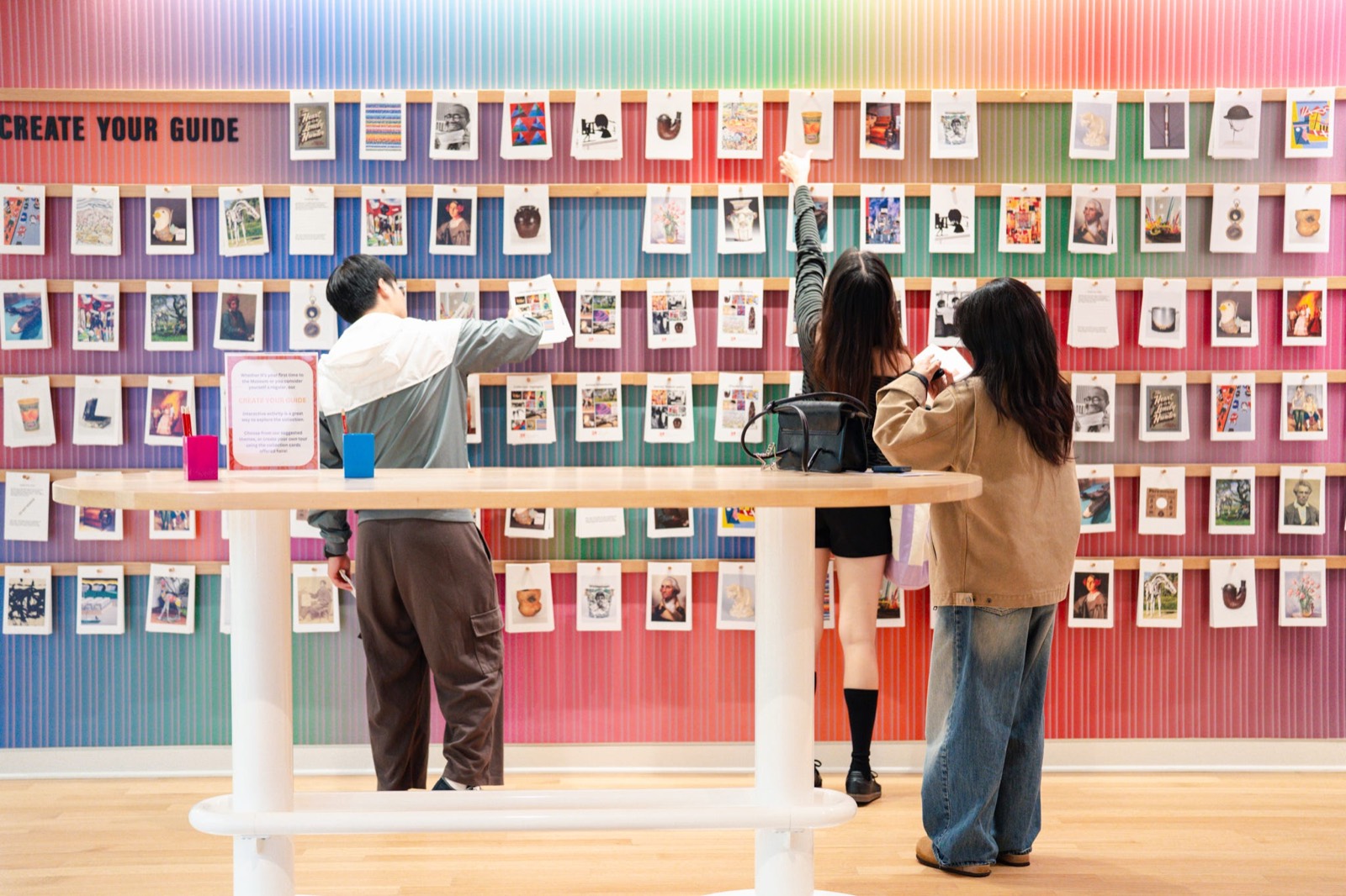 Learners exploring a gallery wall of student artwork