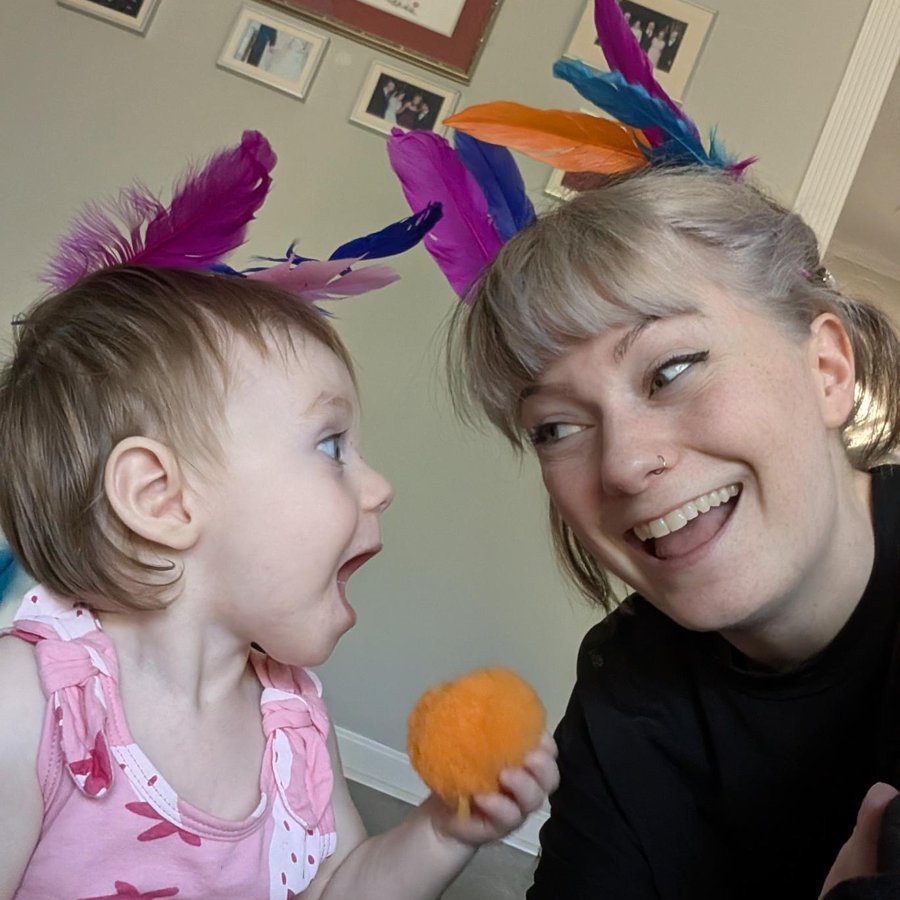 Michelle S. Repass, Finance and Operations Manager, wearing feather headbands with a delighted toddler